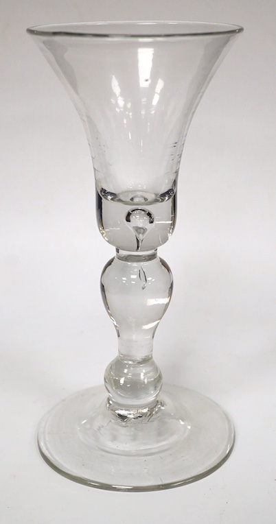 A baluster wine glass, c.1730, the bell shaped bowl with basal tear, inverted baluster stem, conical foot, 15.6cm high. Condition - good